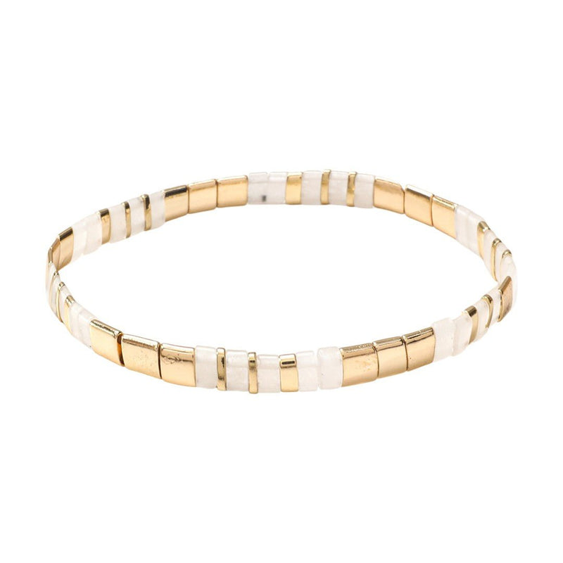 Bracelet souple à enfiler en perles dorées et blanches rectangulaires, style minimaliste et lumineux.