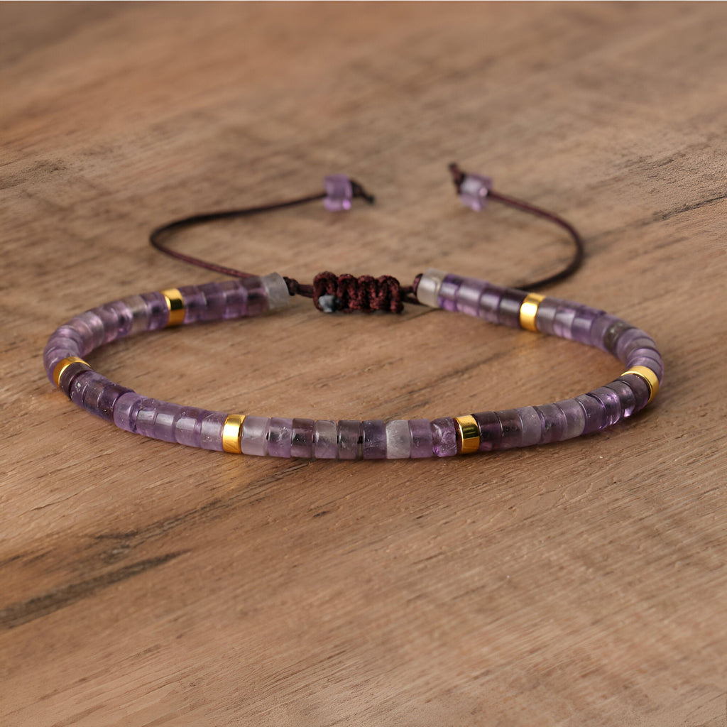 Bracelet mixte en perles heishi améthyste violettes avec détails dorés et fermeture coulissante noire.