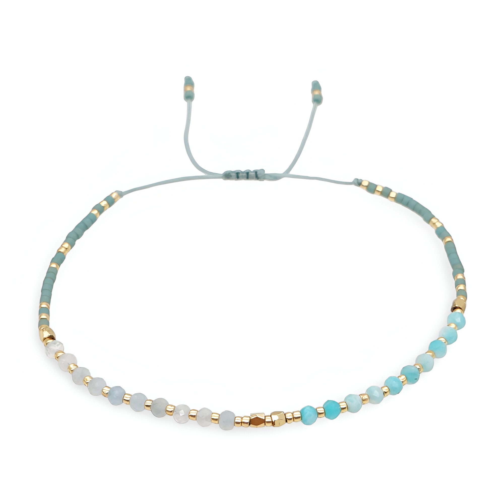 Bracelet fin en perles heishi turquoise et blanches avec détails dorés et cordon ajustable gris clair.