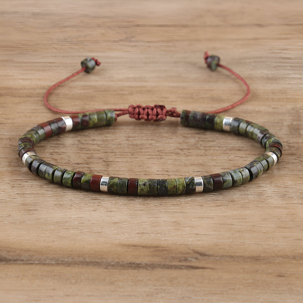 Bracelet réglable perles heishi kaki en pierre de sang avec détails métalliques argentés.