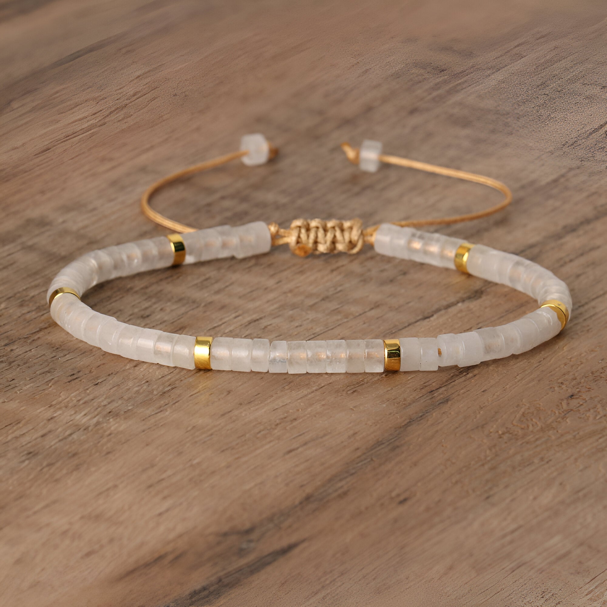 Bracelet mixte en perles heishi quartz blanc avec détails dorés et fermoir ajustable.