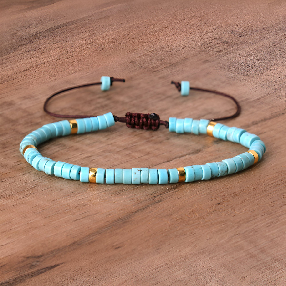 Bracelet mixte en perles heishi turquoises avec trois perles dorées et corde réglable marron.