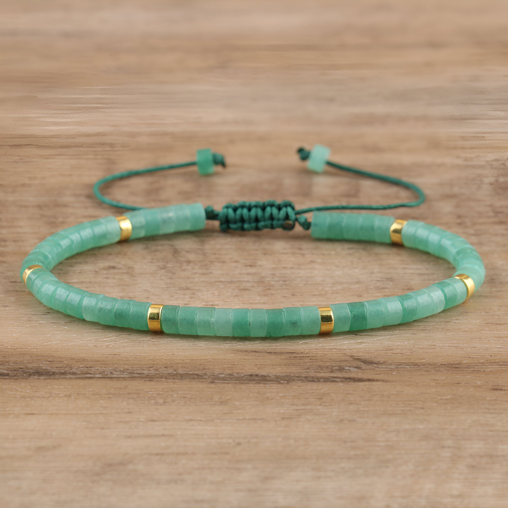 Bracelet mixte perles heishi aventurine vertes avec détails dorés et cordon ajustable noir.