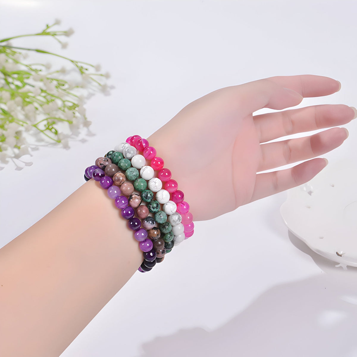 Bracelets en perles naturelles multicolores, style Maia, portée sur poignet féminin, perles lisses et rondes.