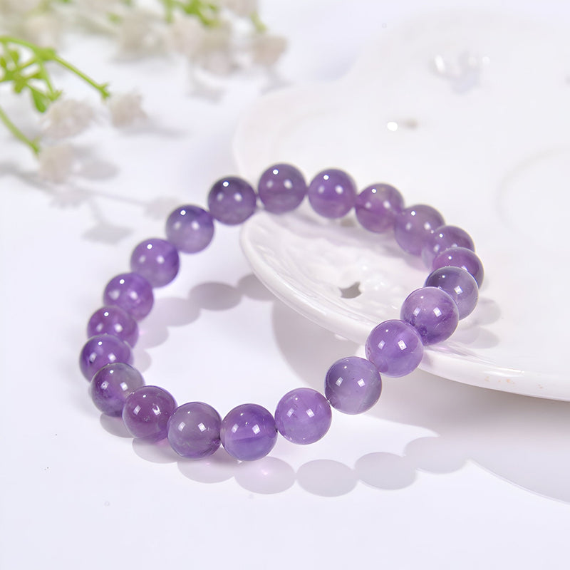 Bracelet en perles d'améthyste violet brillant, finition lisse et ronde, style élégant féminin.