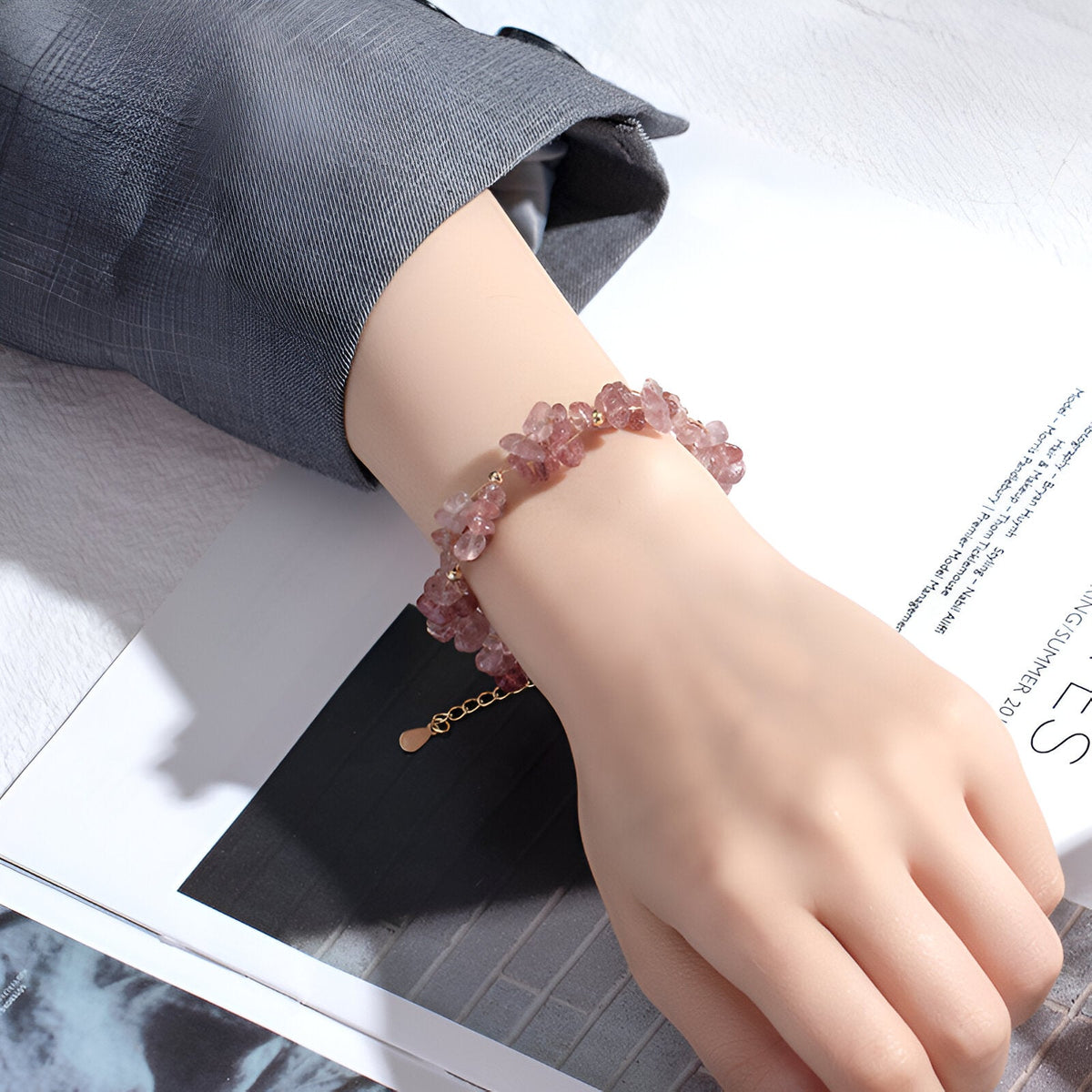 Bracelet femme en pierres de cristal rose clair, design naturel avec fermoir doré ajustable.