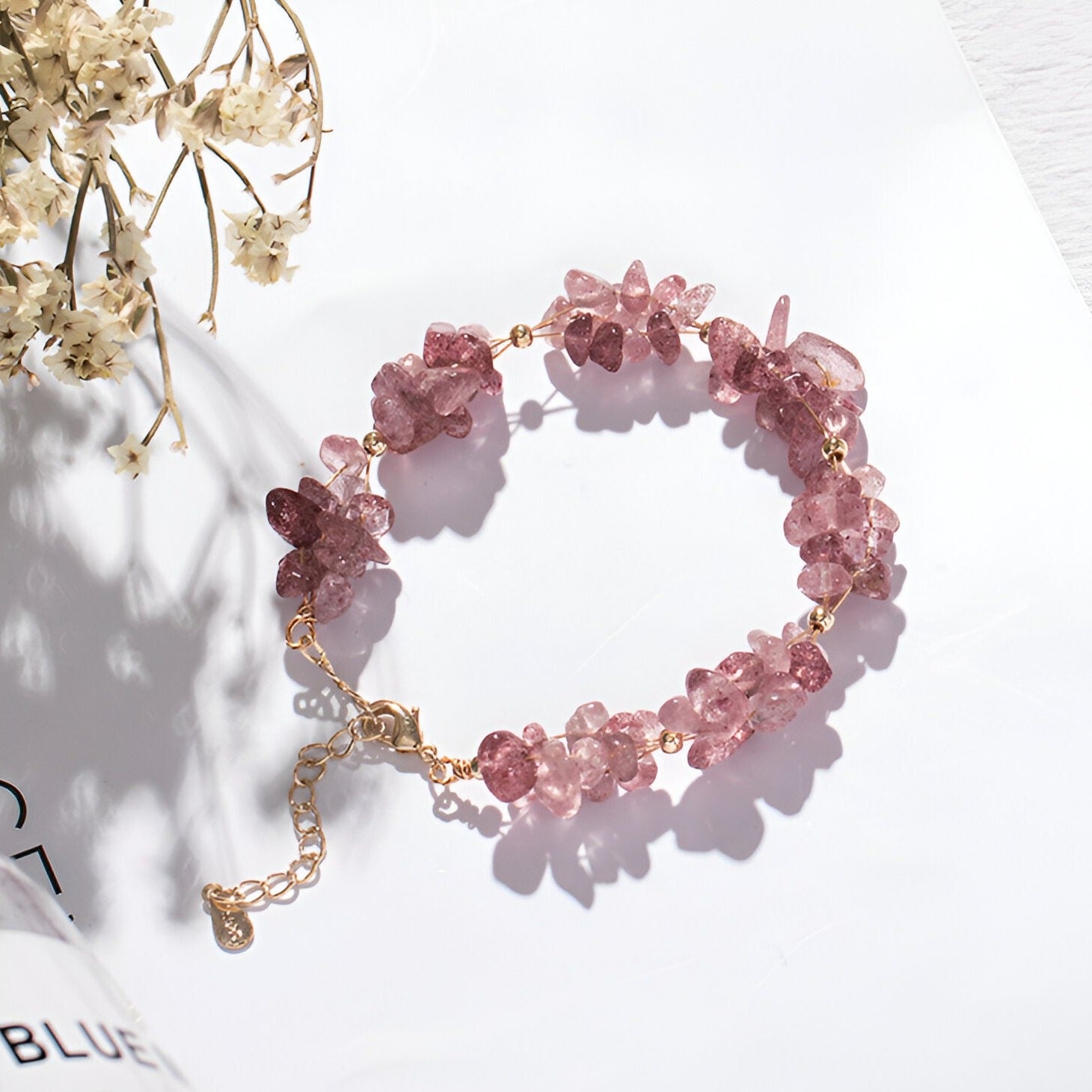 Bracelet femme en pierres de cristal roses naturelles avec chaîne ajustable dorée.
