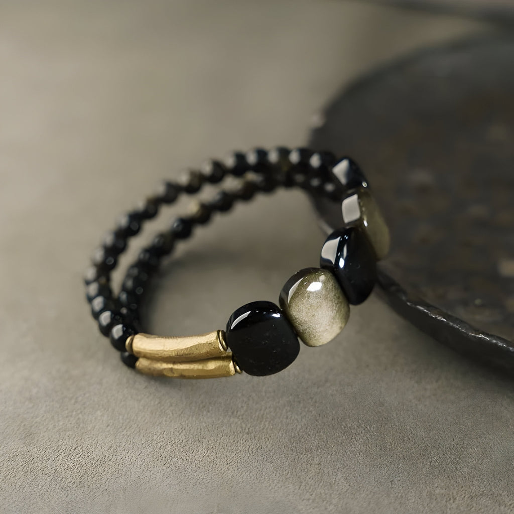 Bracelet double rang en pierres d'obsidienne noire et dorée avec accents en laiton mat.