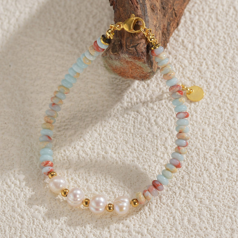 Bracelet femme perles blanches, pierres naturelles bleu clair et rose, fermoir et détails dorés.