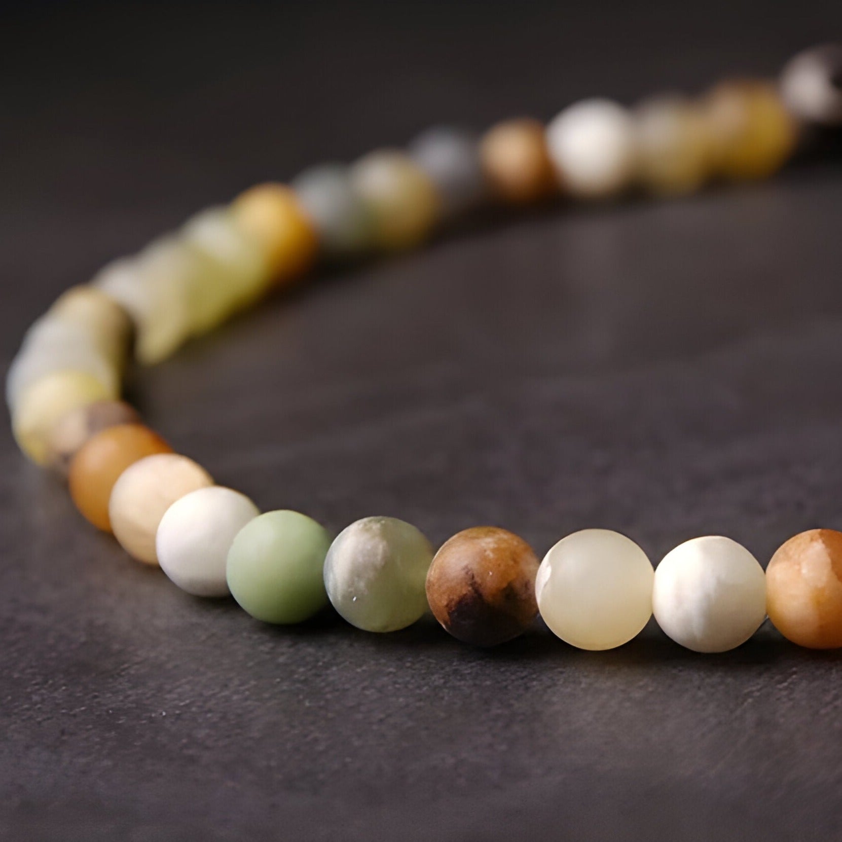 Bracelet pour femme en perles rondes d'agate jaune multicolore aux tons naturels variations beiges, blancs, verts et bruns.