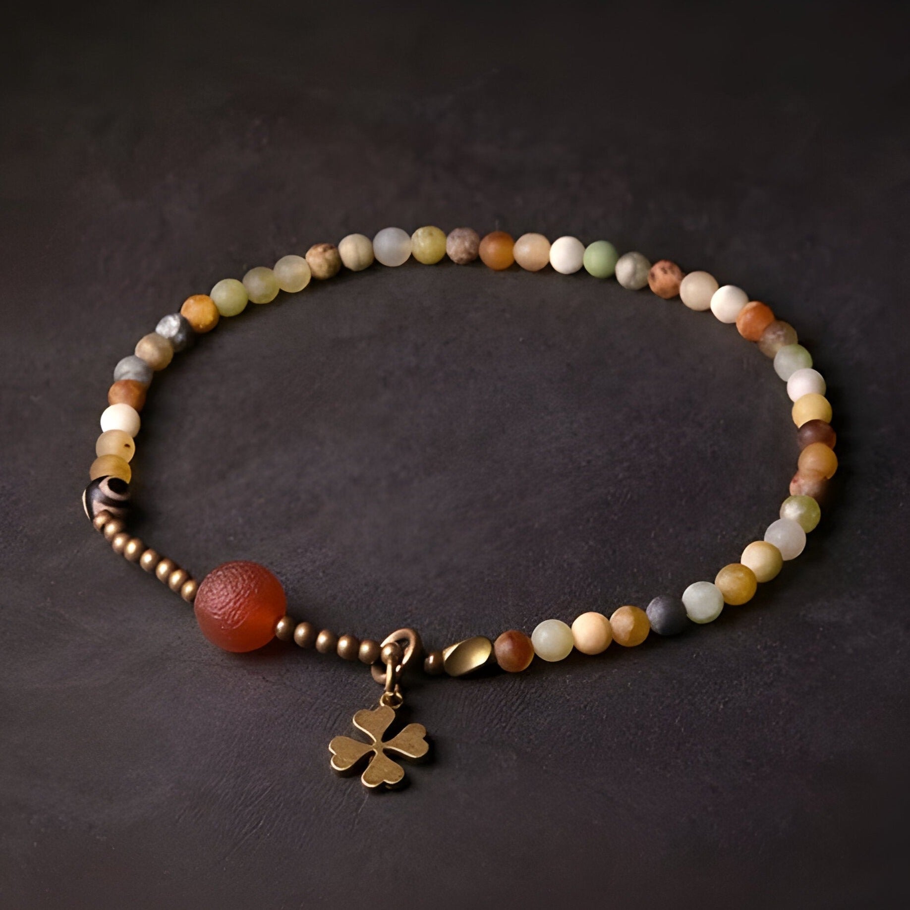 Bracelet femme en perles d'agate jaune multicolores avec breloque trèfle en métal doré.