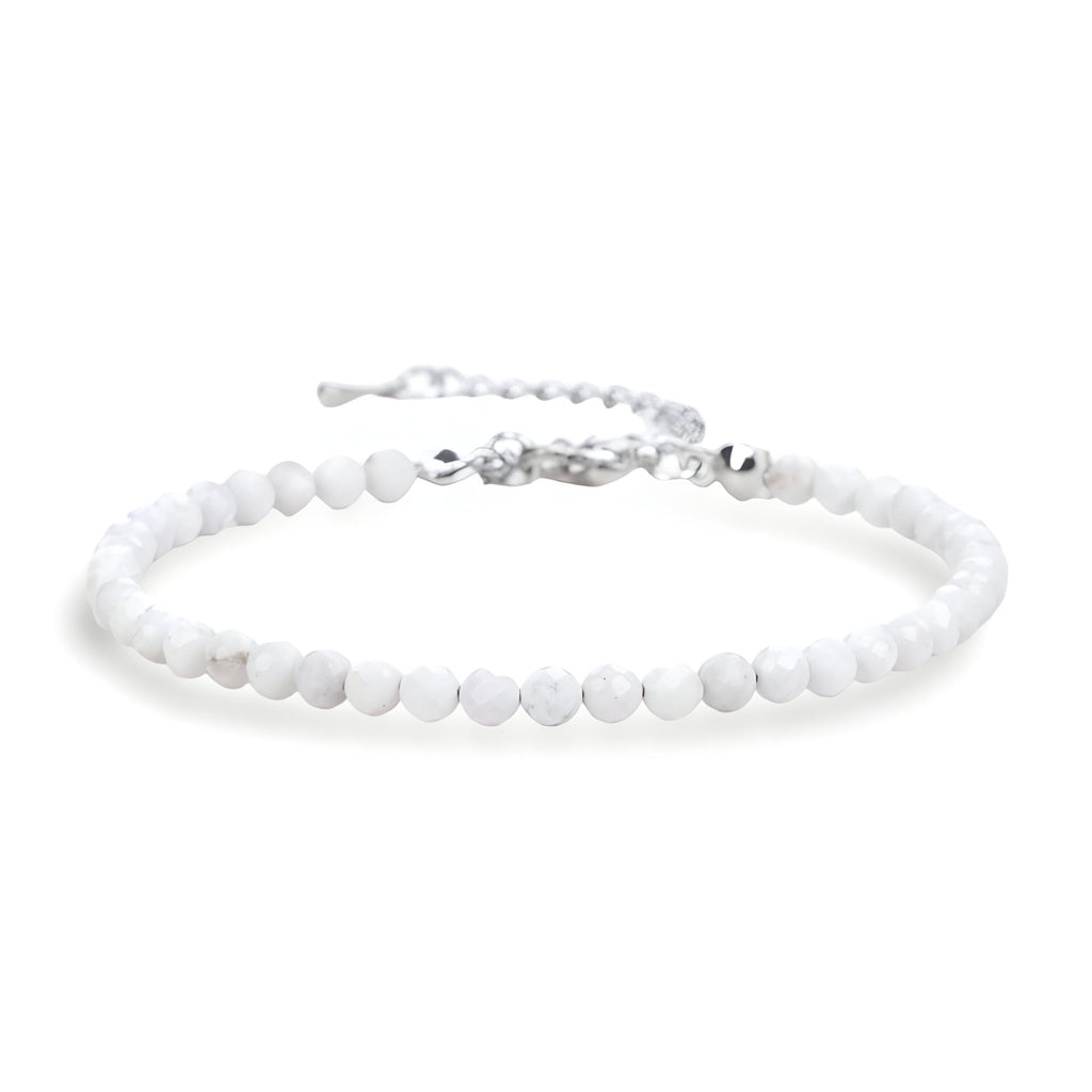 Bracelet fin en perles blanches naturelles avec fermoir argenté et chaîne réglable.