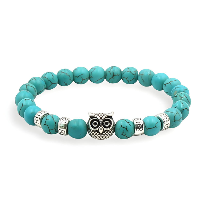 Bracelet turquoise en pierres naturelles avec perles argentées et pendentif hibou détaillé en métal.