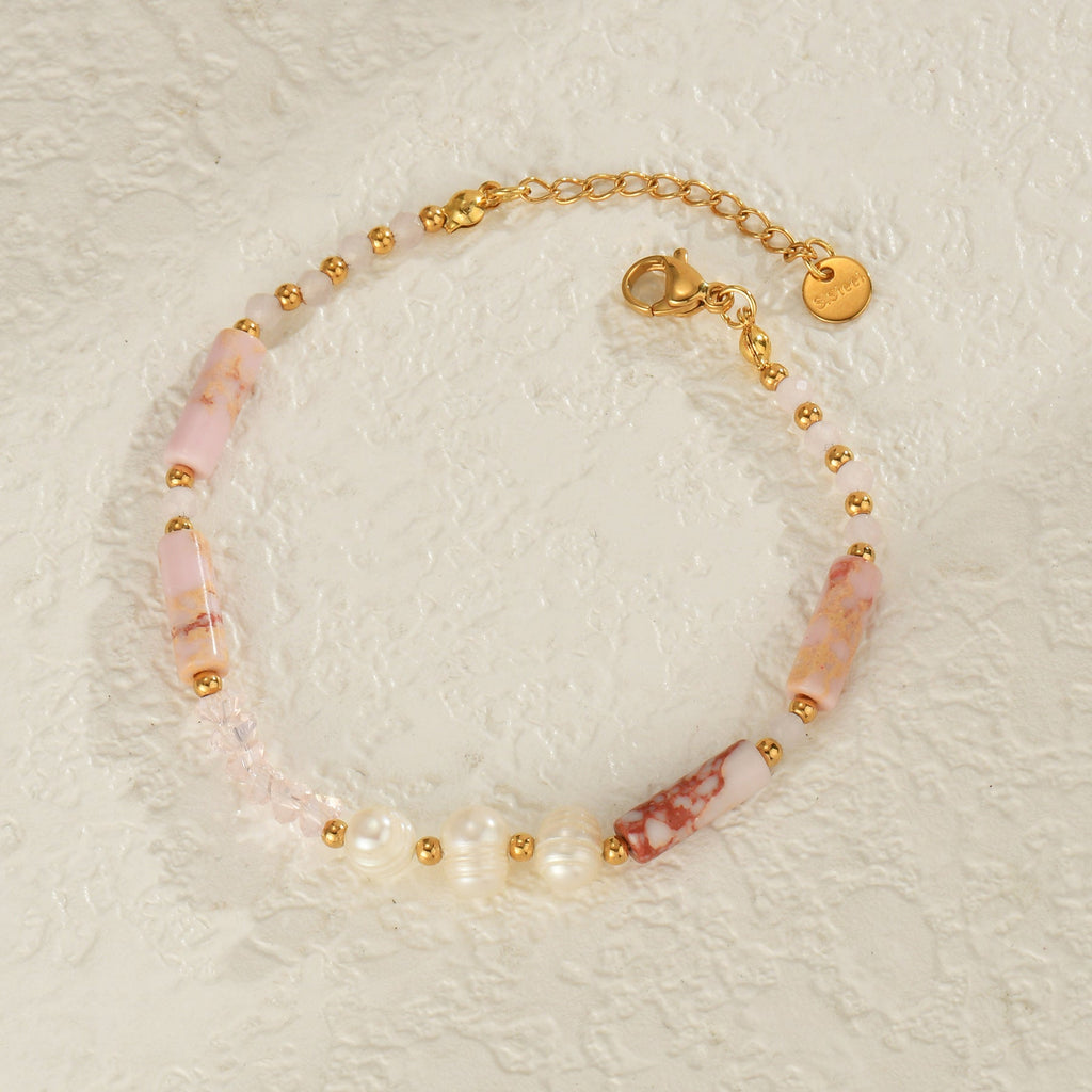 Bracelet femme avec perles dorées et pierres naturelles rose pâle sur chaîne fine dorée ajustable.