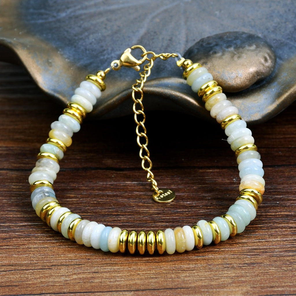 Bracelet femme en pierres de cristal blanches et dorées avec chaîne réglable en métal doré.