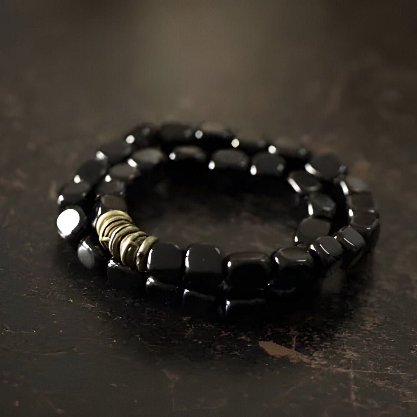 Bracelet multi-couches pour femme en pierres cubiques d'onyx noir avec anneaux cuivrés.