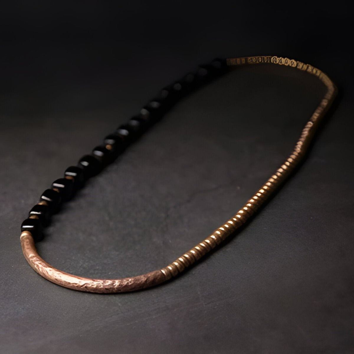 Bracelet femme en perles d'onyx noires et maillons fins en cuivre texturé.