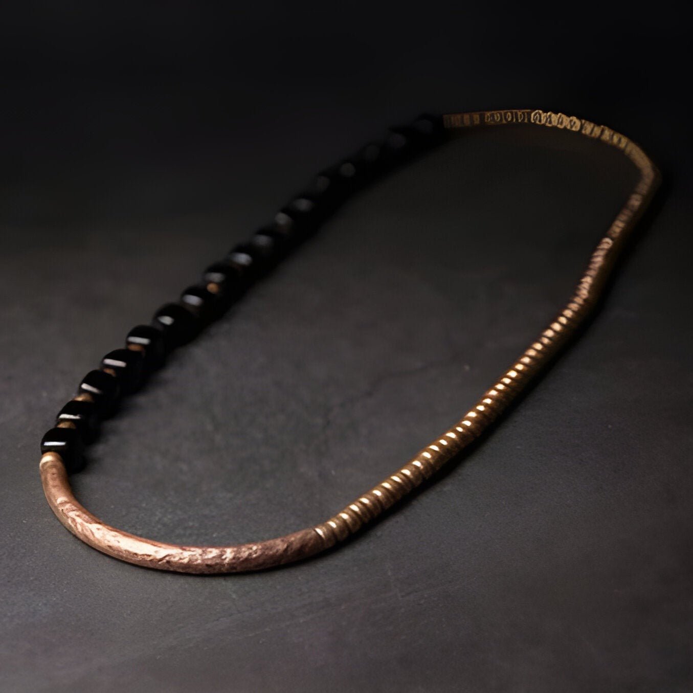 Bracelet femme en perles d'onyx noires et maillons fins en cuivre texturé.
