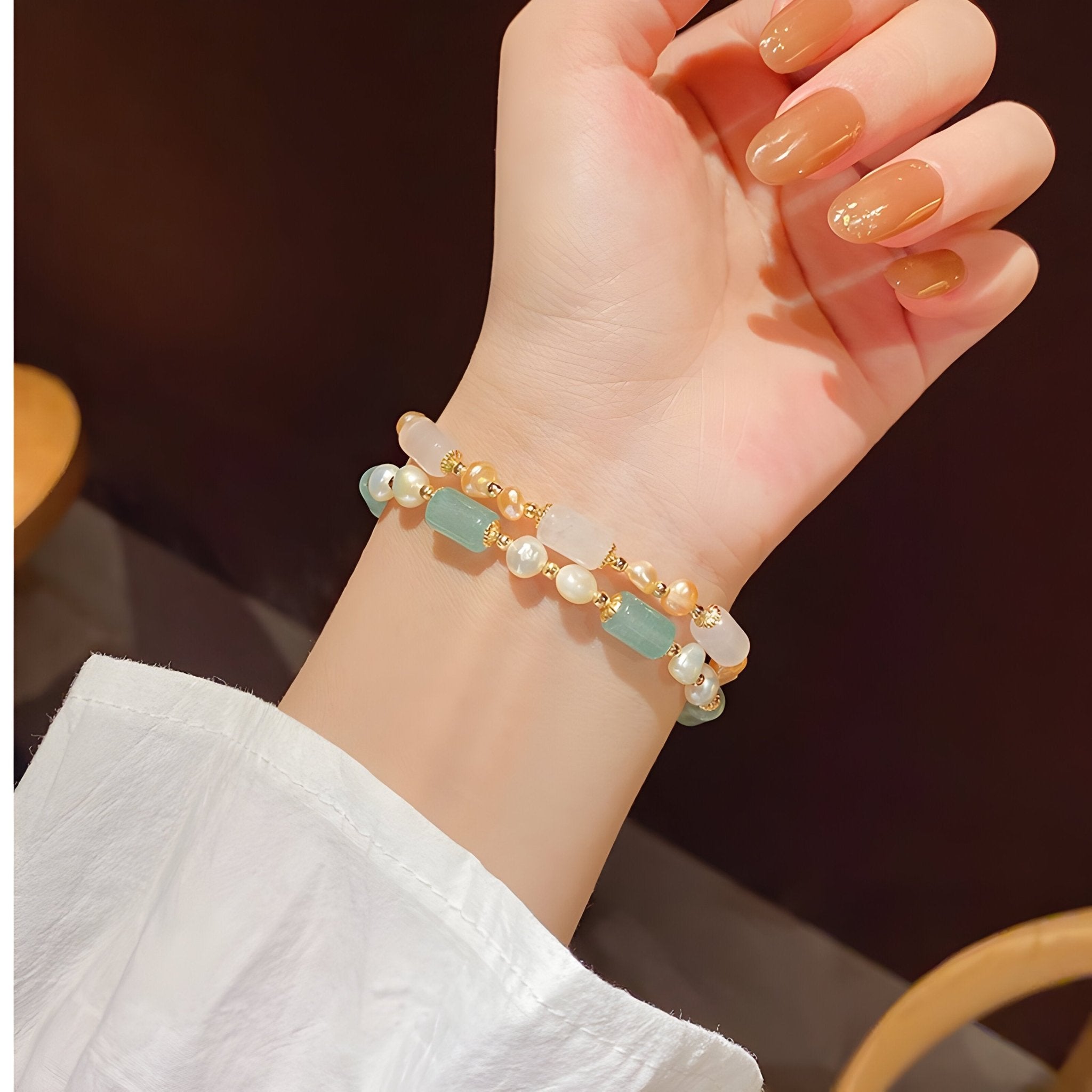 Bracelet femme en pierres naturelles vertes et perles blanches sur fil élastique élégant.