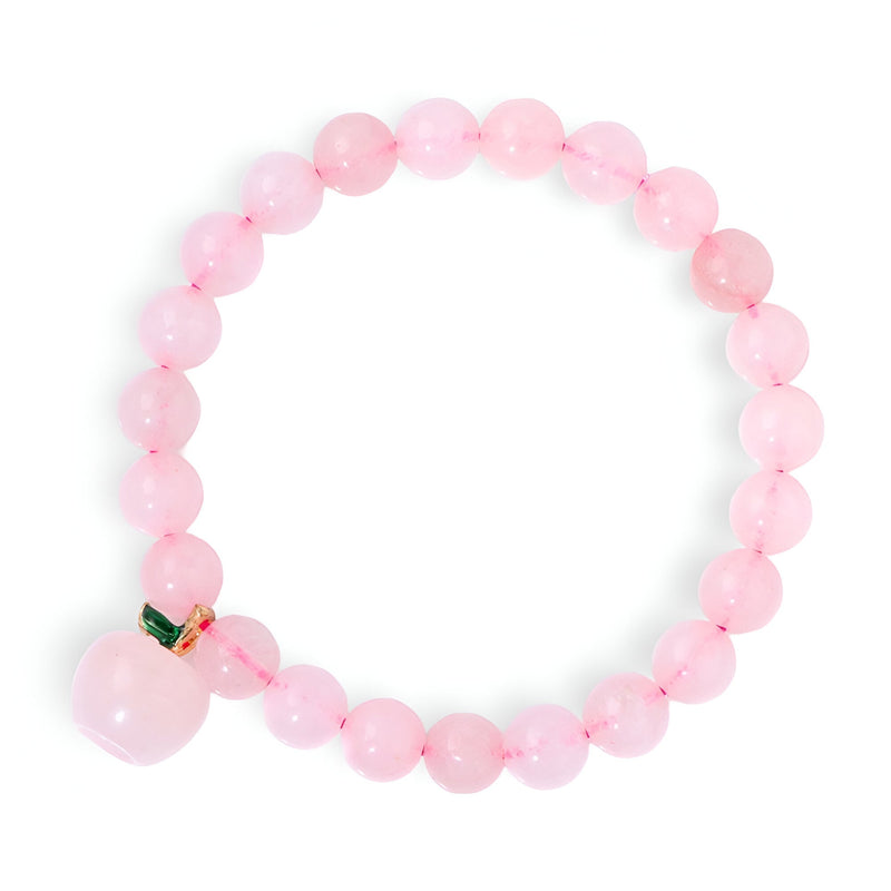 Bracelet élastique en perles rondes de quartz rose avec pendentif pomme assorti et détail métallique doré.