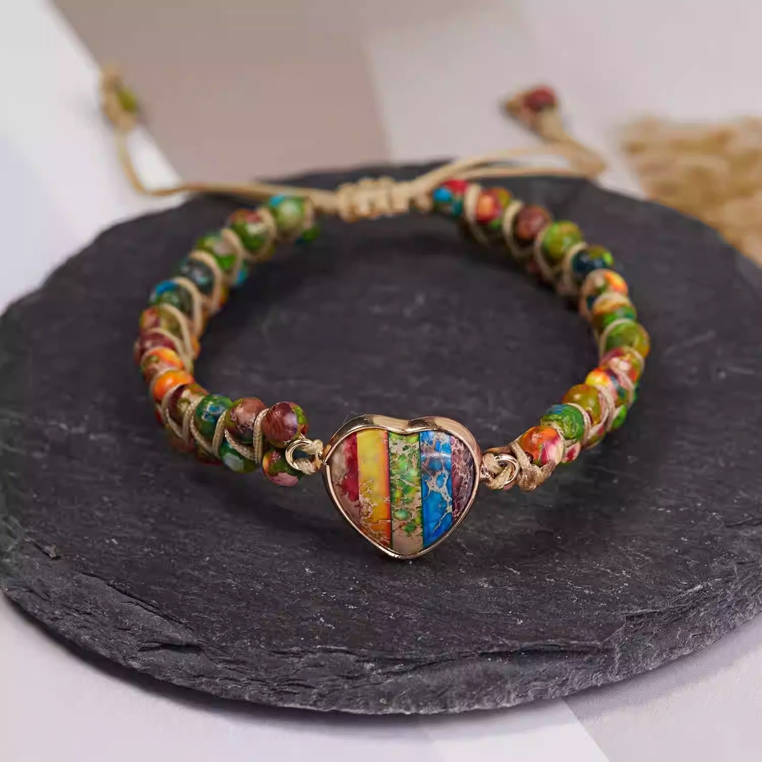 Bracelet femme en cordes beige avec pierres naturelles multicolores et pendentif cœur rayé en pierres fines.