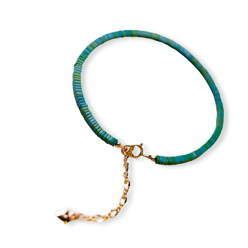 Bracelet fin en perles turquoise et vertes avec fermoir doré et chaîne de réglage.