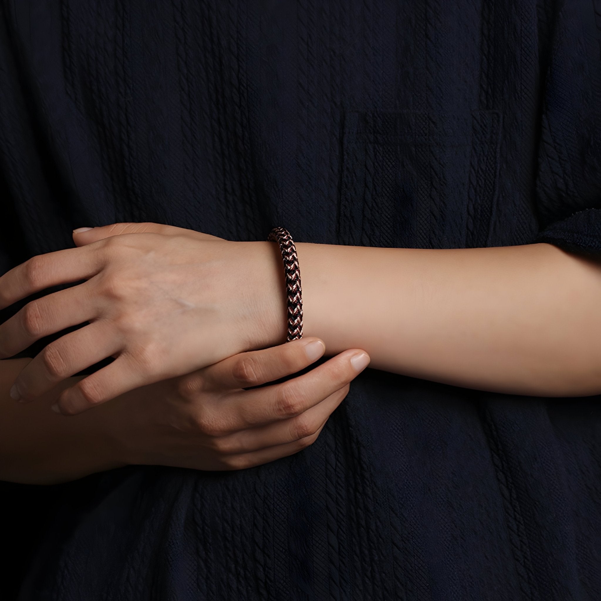 Bracelet en polyester marron tressé, style unisexe, porté au poignet sur fond sombre.