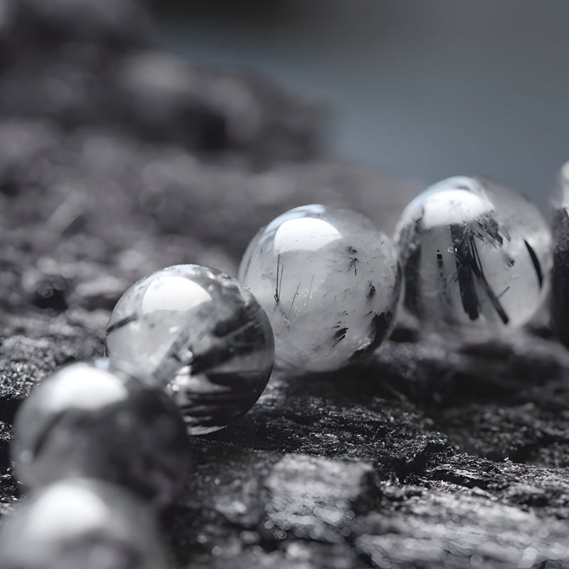 Bracelet mixte perles rondes en quartz noir transparent avec inclusions, cordon élastique noir.