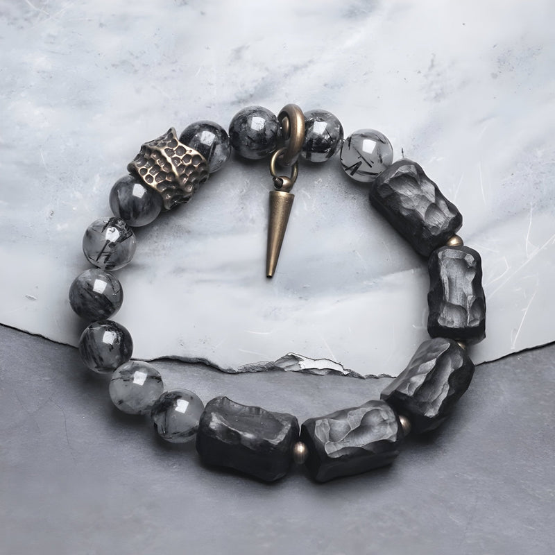 Bracelet mixte en quartz noir taillé et bois d’ébène avec breloques en métal cuivré, modèle Vika.
