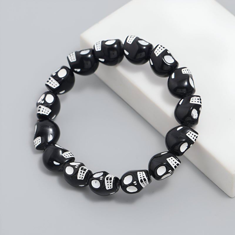 Bracelet pour homme en résine noire avec perles crânes assemblés blanches, style gothique.