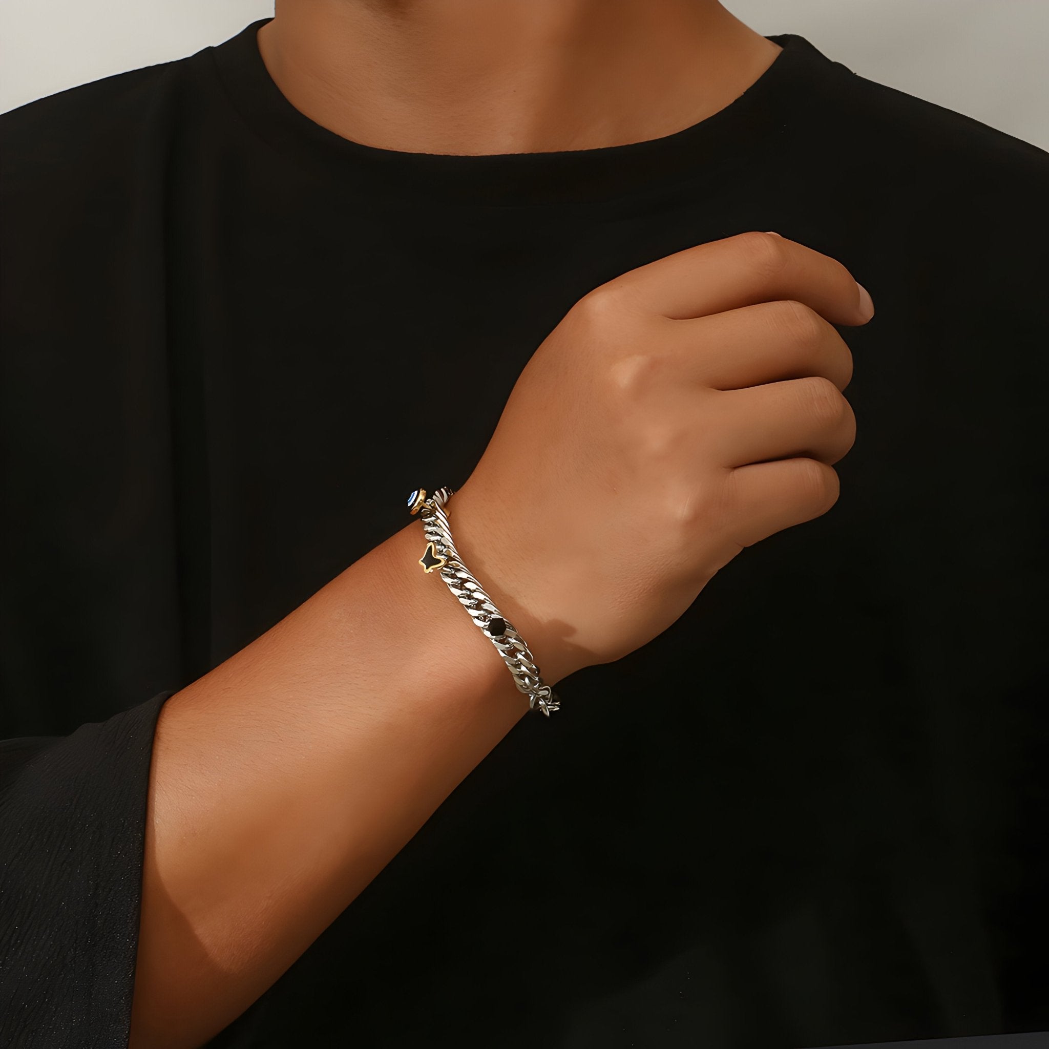 Bracelet en titane argenté pour homme avec chaîne épaisse et charms œil et papillon.