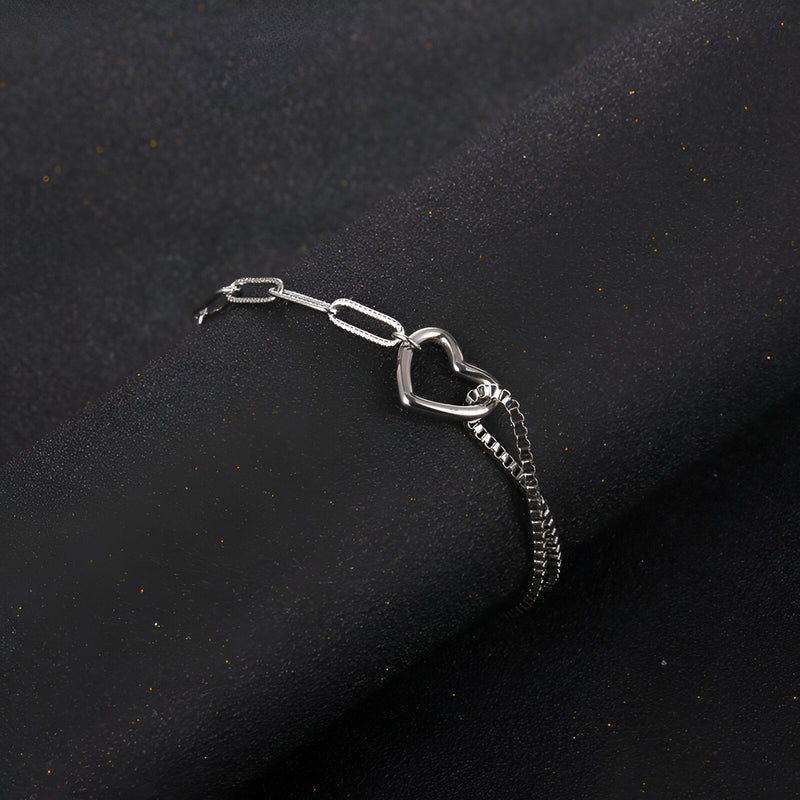 Bracelet en titane argenté avec double maille et charm cœur ajouré, design mixte.