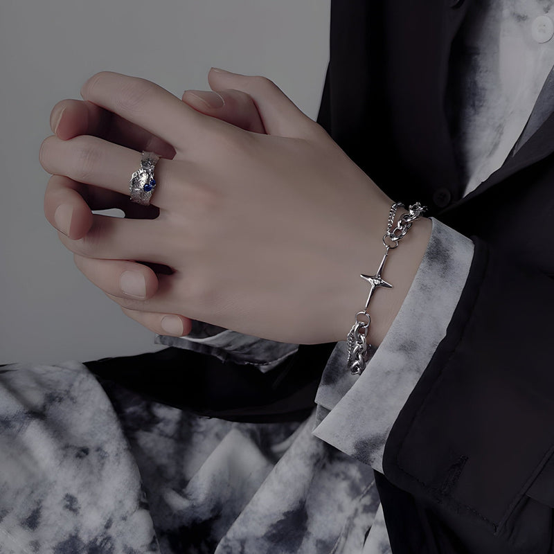 Bracelet en titane argenté à double maille avec croix scintillante, porté au poignet masculin.