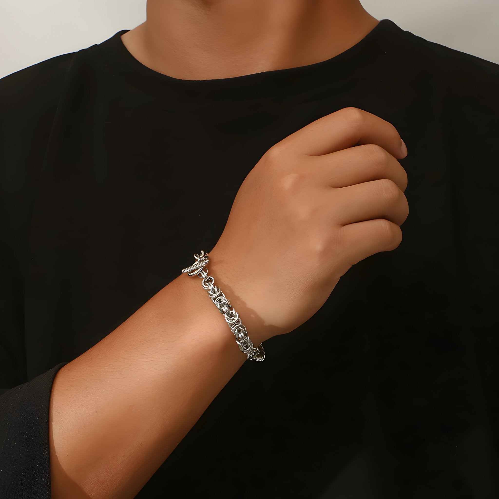 Bracelet homme en titane argenté à maille cubaine entremêlée, finition brillante, porté au poignet.