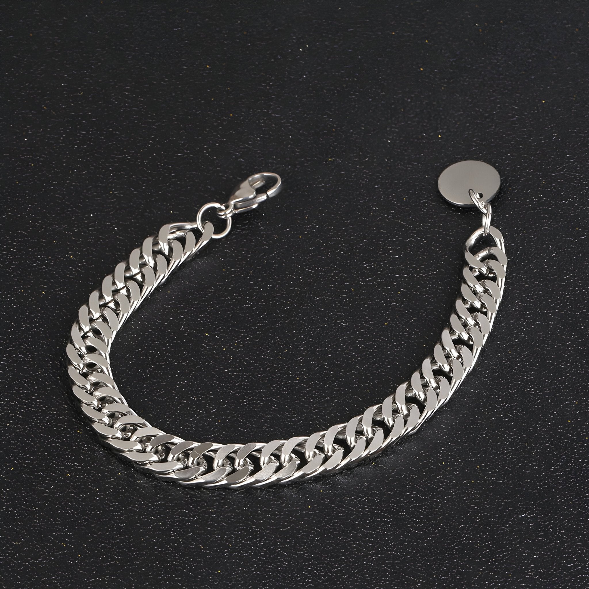 Bracelet en titane argenté à maille cubaine avec fermoir mousqueton et médaille ronde lisse.