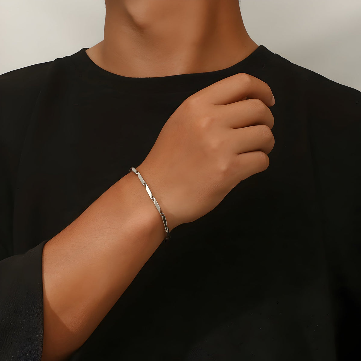 Bracelet en titane argenté maille irrégulière fin et élégant porté au poignet masculin.