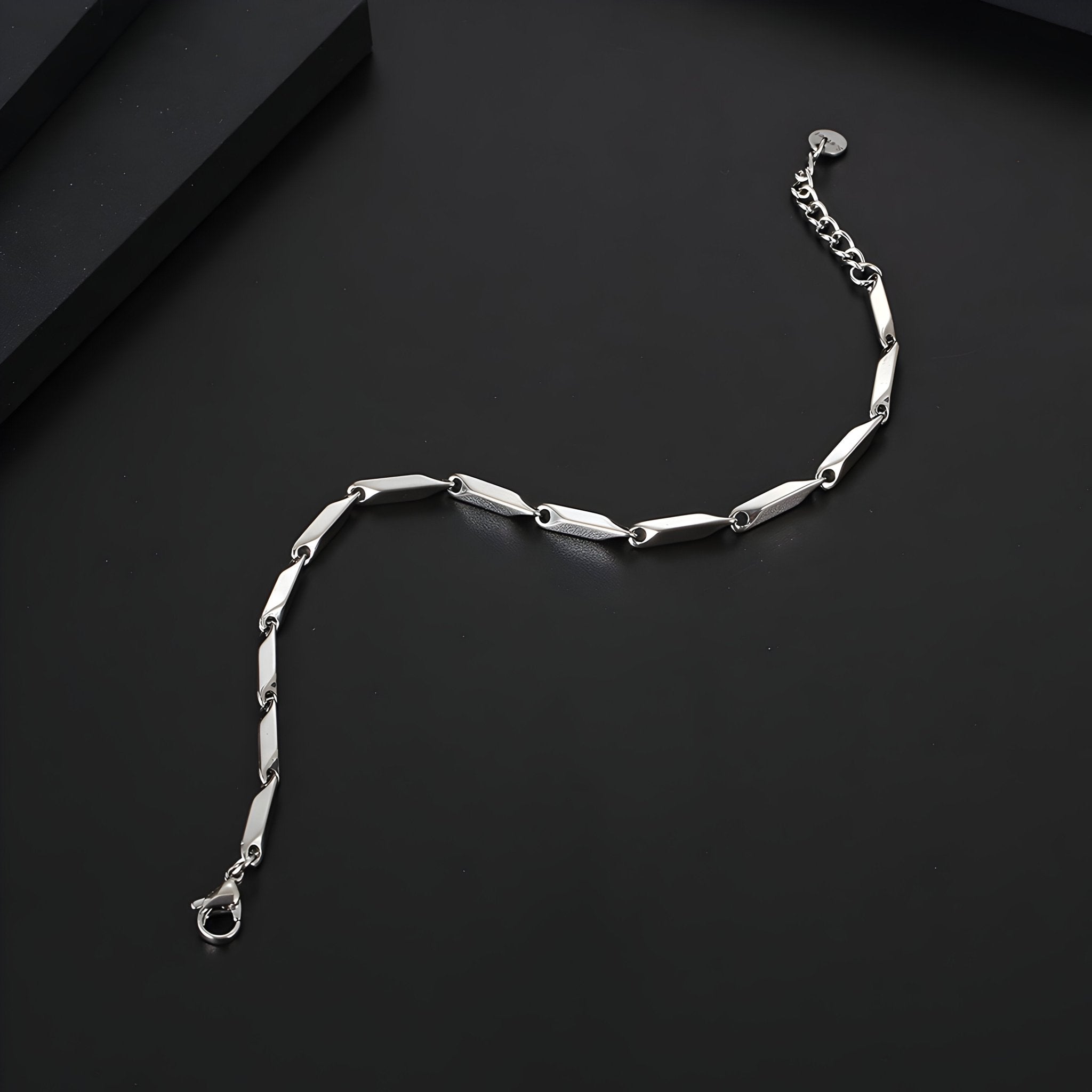 Bracelet homme en titane argenté avec maille irrégulière et fermoir mousqueton.