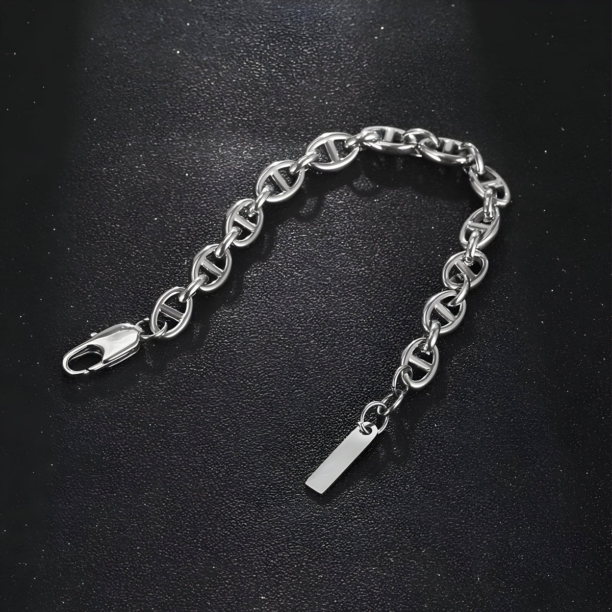 Bracelet homme en titane argenté avec maille marine et fermoir mousqueton sur fond noir.