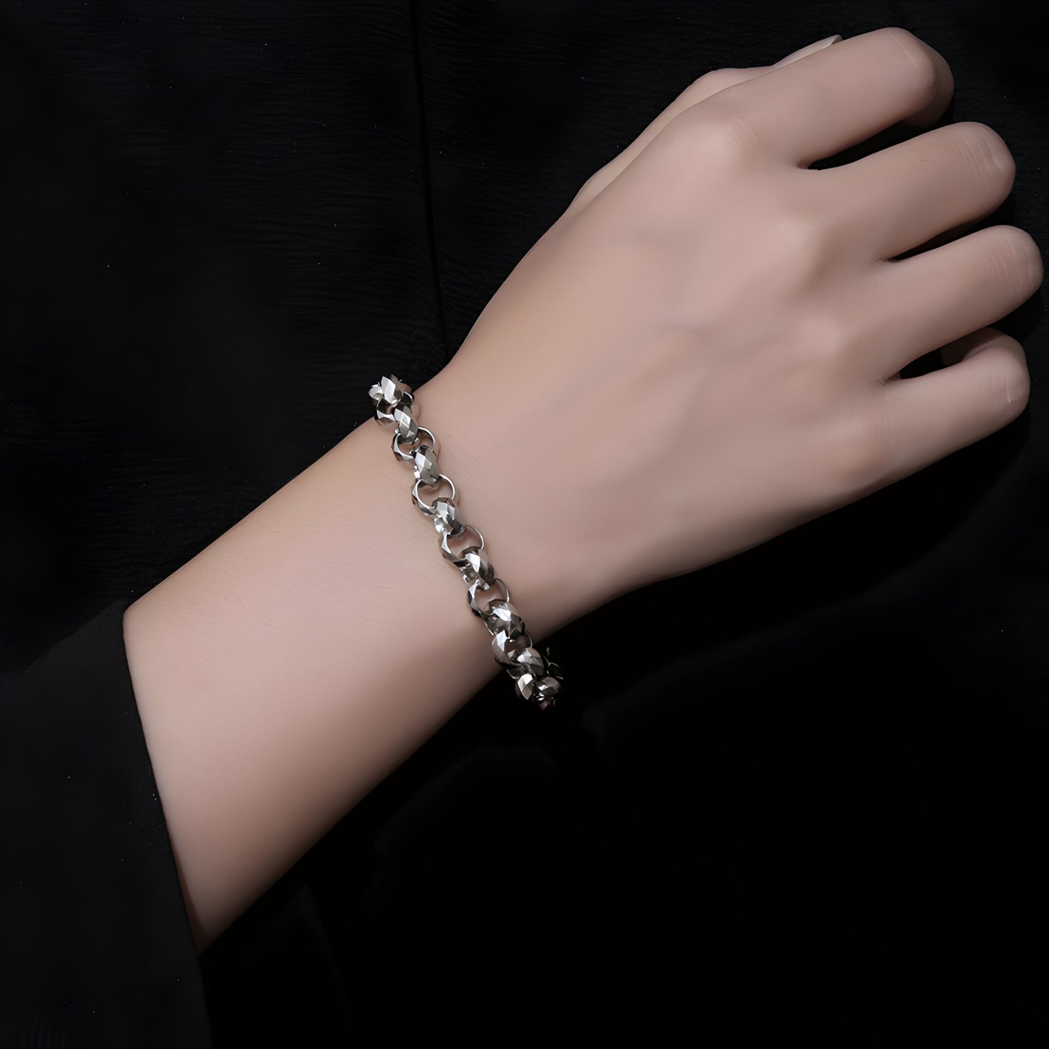 Bracelet en titane argenté à maille rolo avec pièce centrale ronde, porté au poignet masculin.