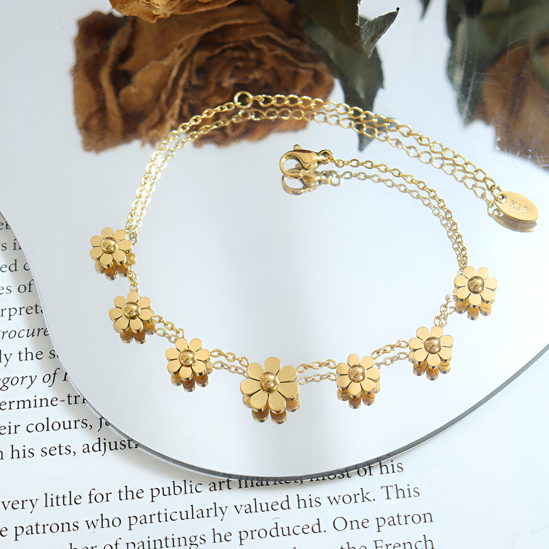 Bracelet en titane plaqué or 18 carats avec fleurs délicates et chaîne fine réglable.