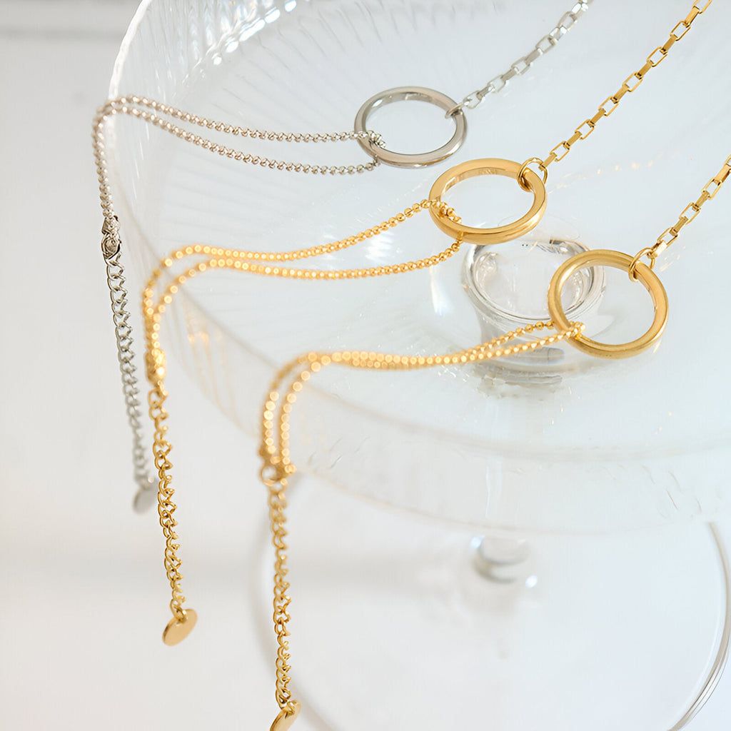 Lot de trois bracelets fins en titane plaqué or 18 carats et argent avec anneaux ronds élégants.