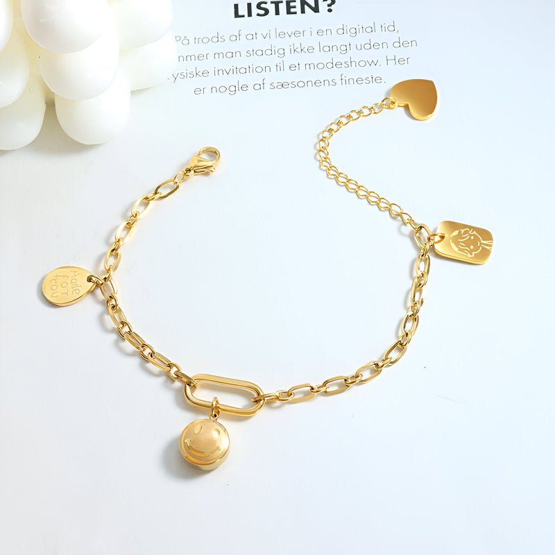 Bracelet or 18 carats en titane avec maillons ovales et médaillons variés, fermoir original en forme de boucle.