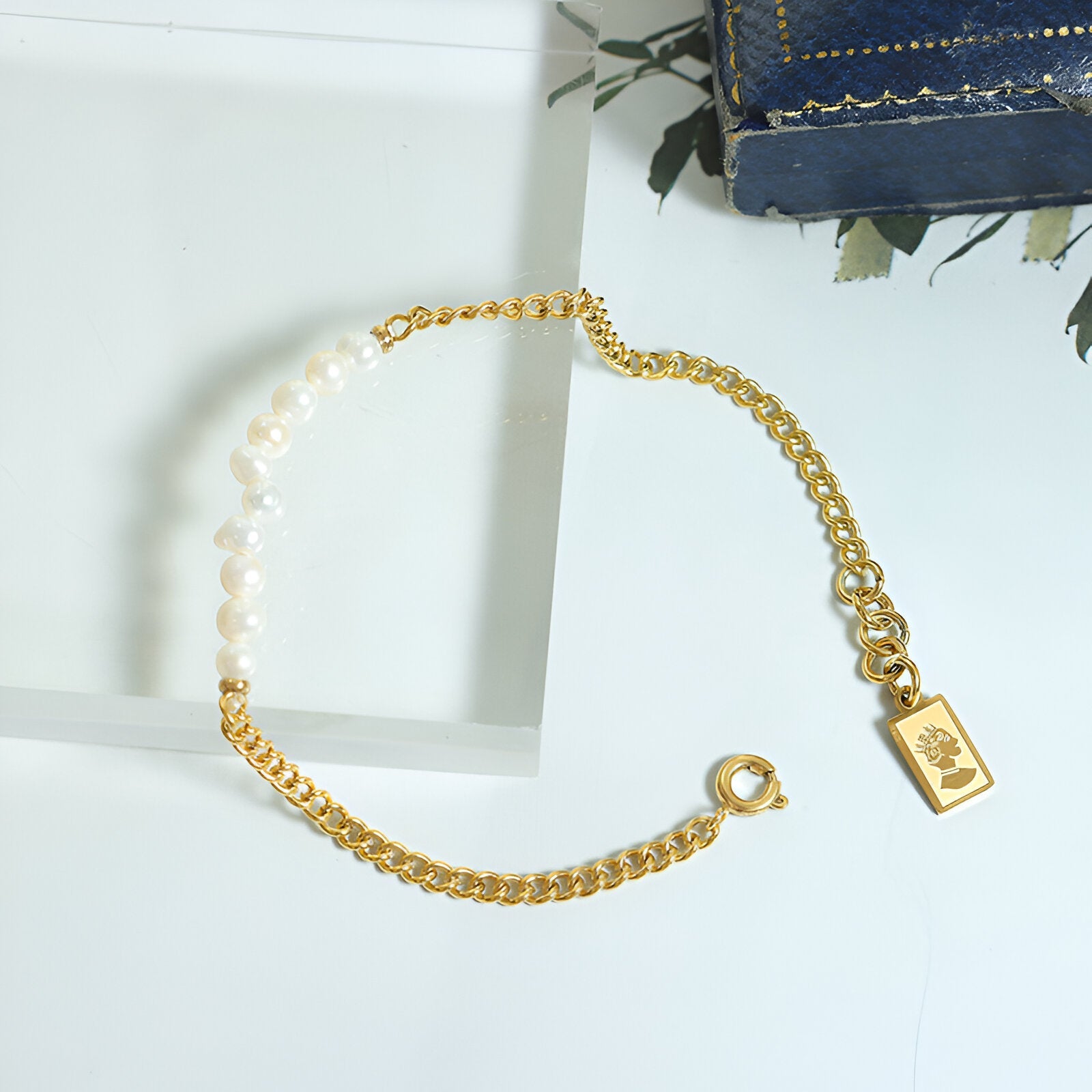 Bracelet doré en titane 18 carats avec perles naturelles blanches et chaîne fine.