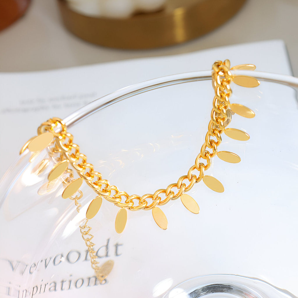 Bracelet chaîne en titane plaqué or 18 carats avec petits médaillons ovales suspendus.