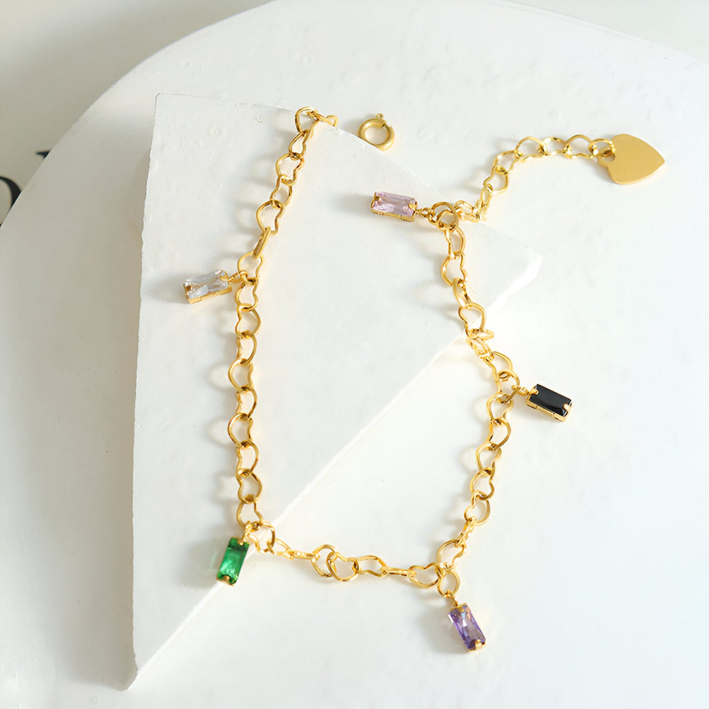 Bracelet en titane plaqué or 18 carats avec chaînette cœur et pierres de zircons colorées vert, violet, rose et noir.