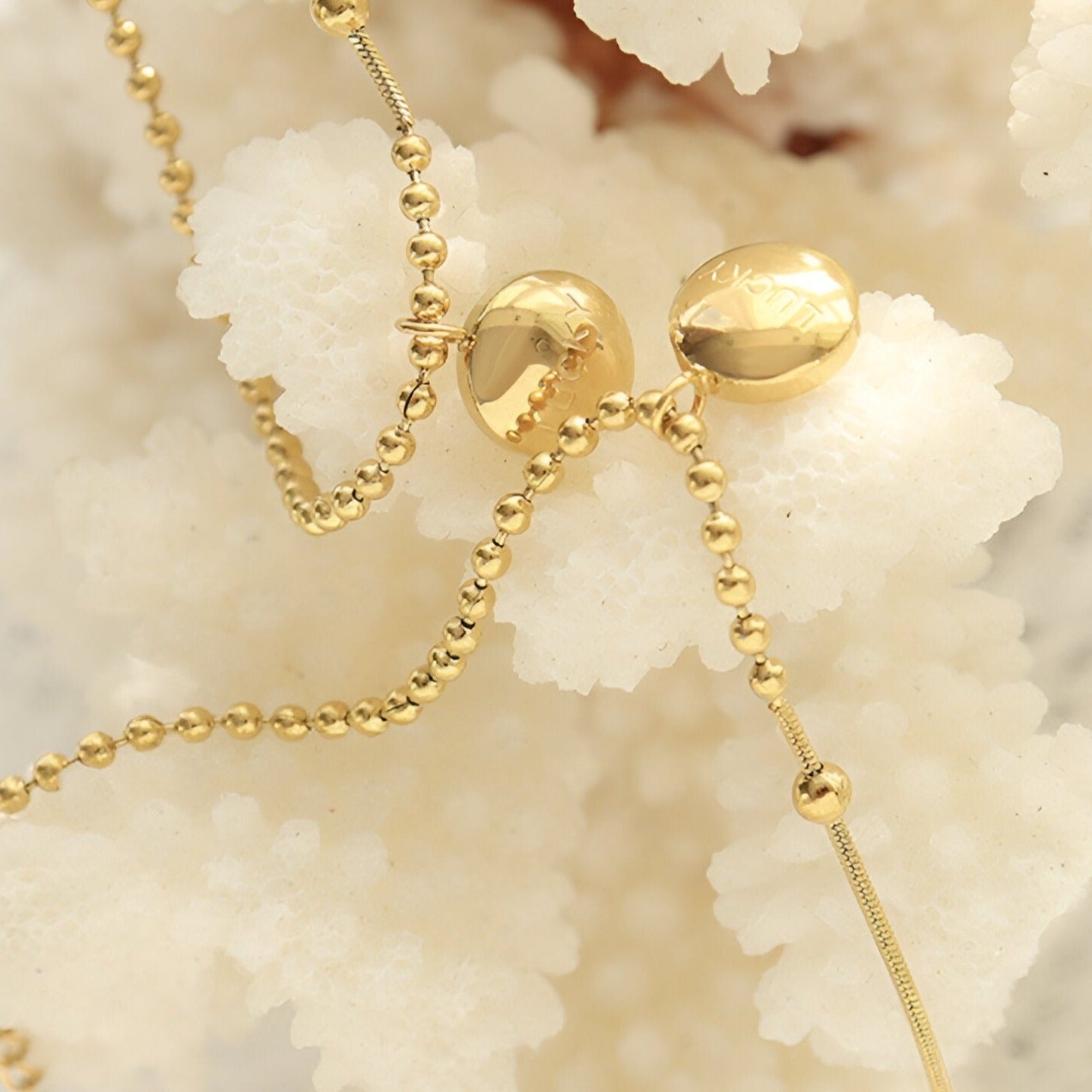 Bracelet en titane plaqué or 18 carats avec médaillon "Lucky" lisse et chaîne à billes fines.