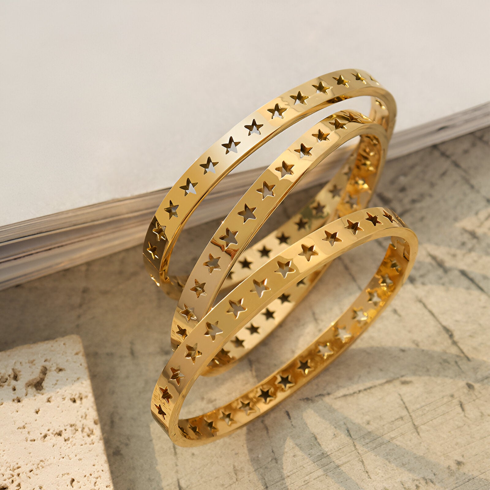 Bracelet en titane plaqué or 18 carats avec motif d'étoiles creuses délicates, modèle fin et élégant.