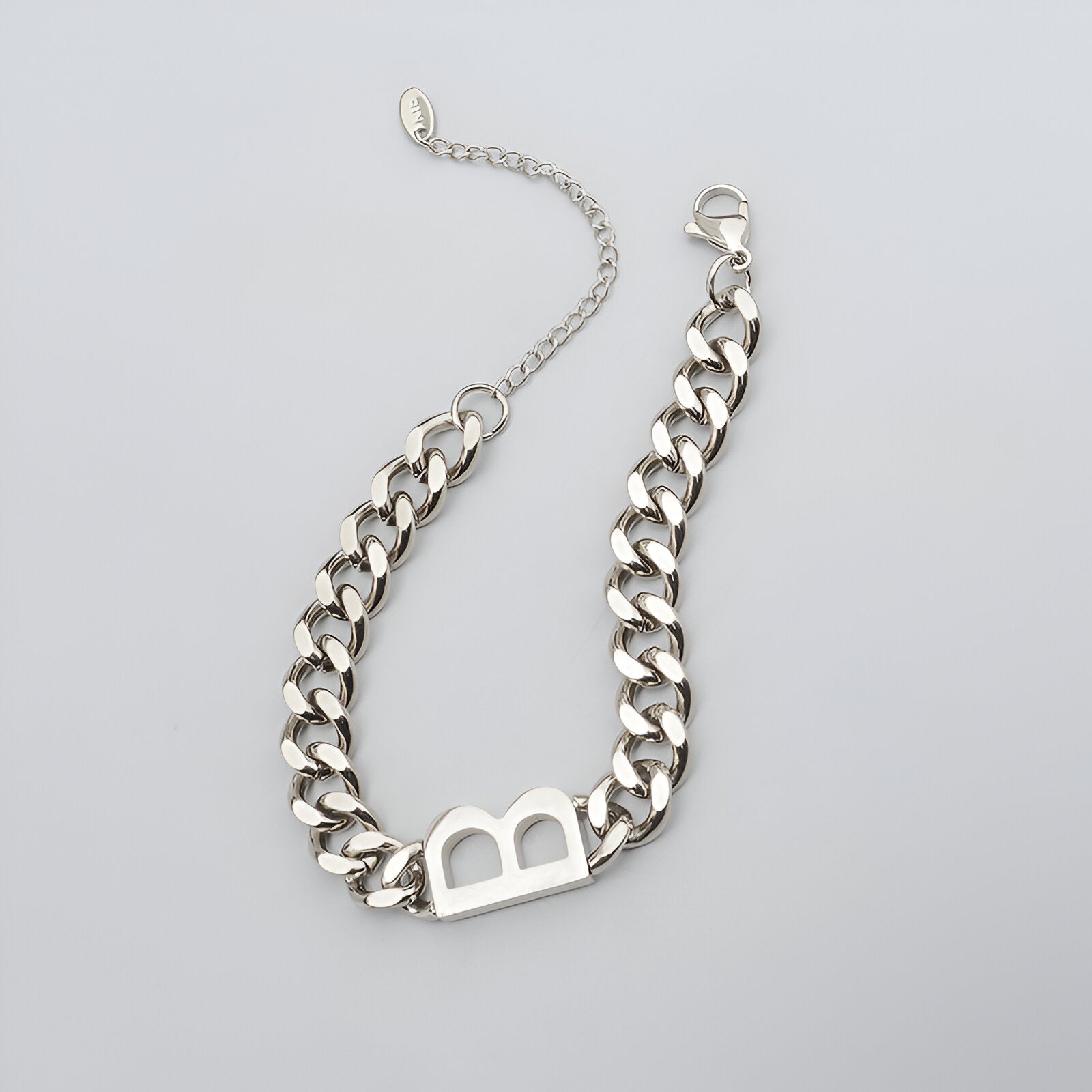 Bracelet chaîne en titane argenté avec lettre "B" ajourée et fermoir mousqueton.