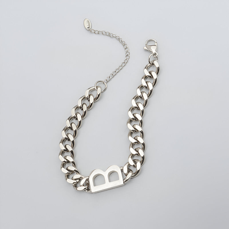 Bracelet chaîne en titane argenté avec lettre "B" ajourée et fermoir mousqueton.