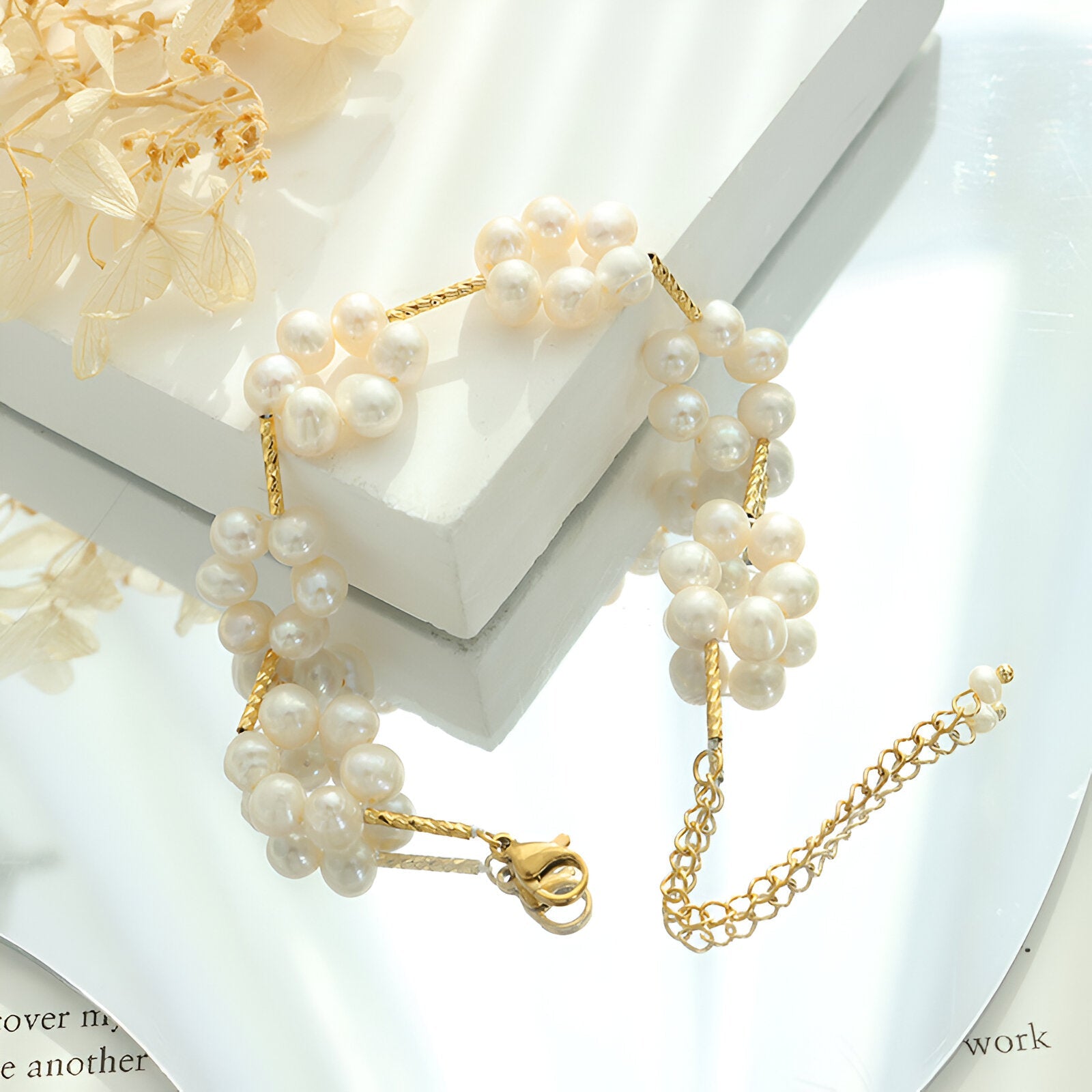Bracelet or en titane 18 carats avec perles blanches formant des fleurs délicates.
